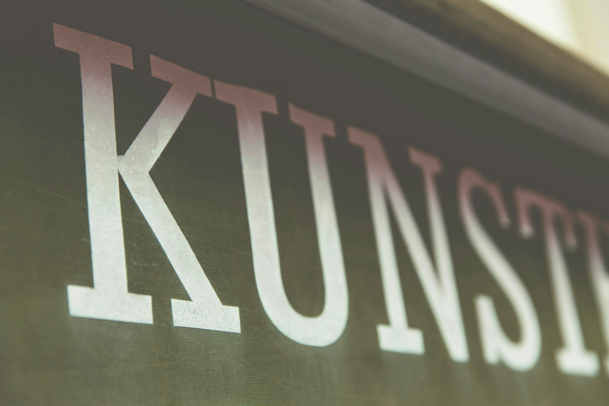 Close-up image of the word 'Kunst' in a stylish font on a dark background.